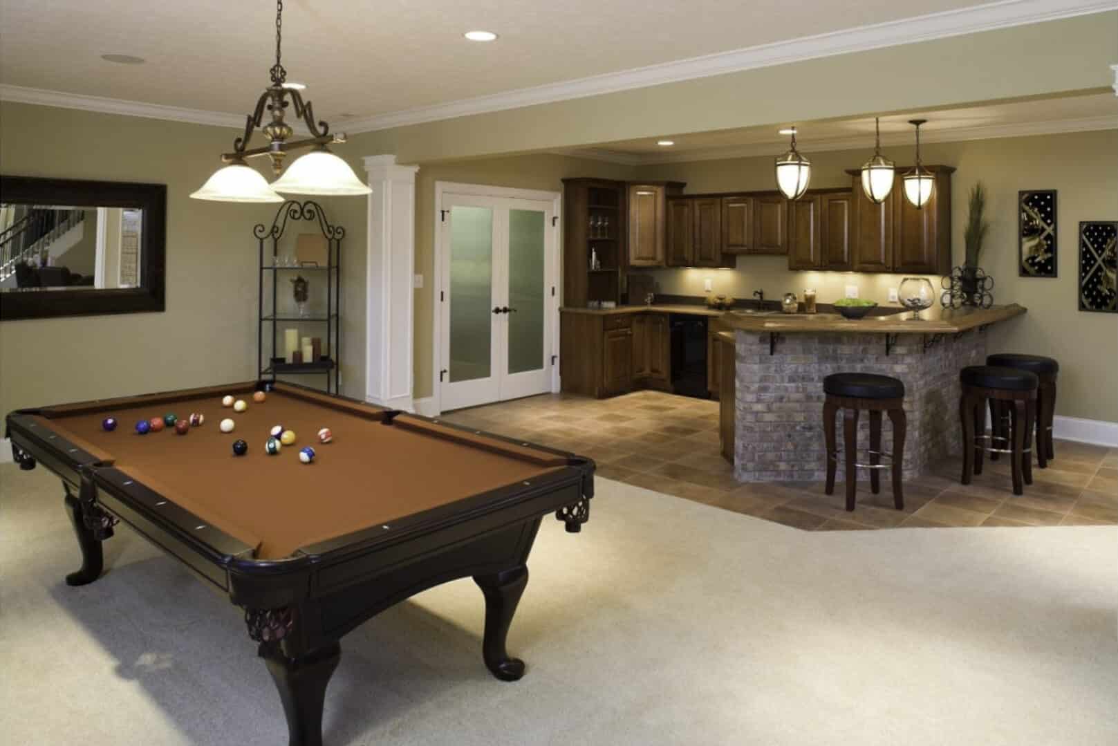 A basement that was turned into an extra room for entertaining with a pool table and kitchen. 